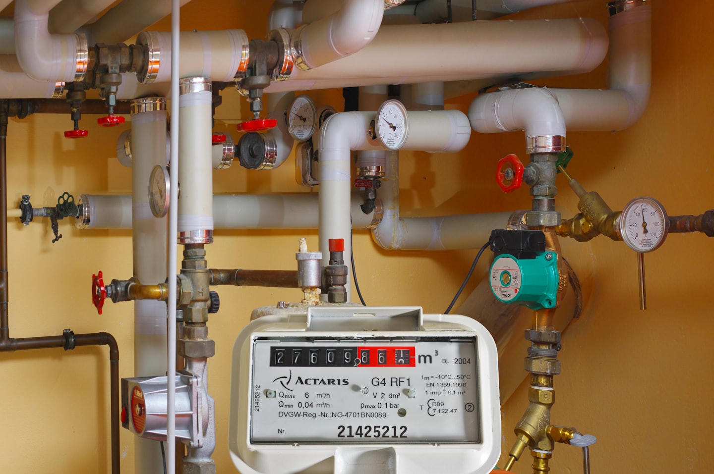 White pipes and brass valves in a plumbing system.